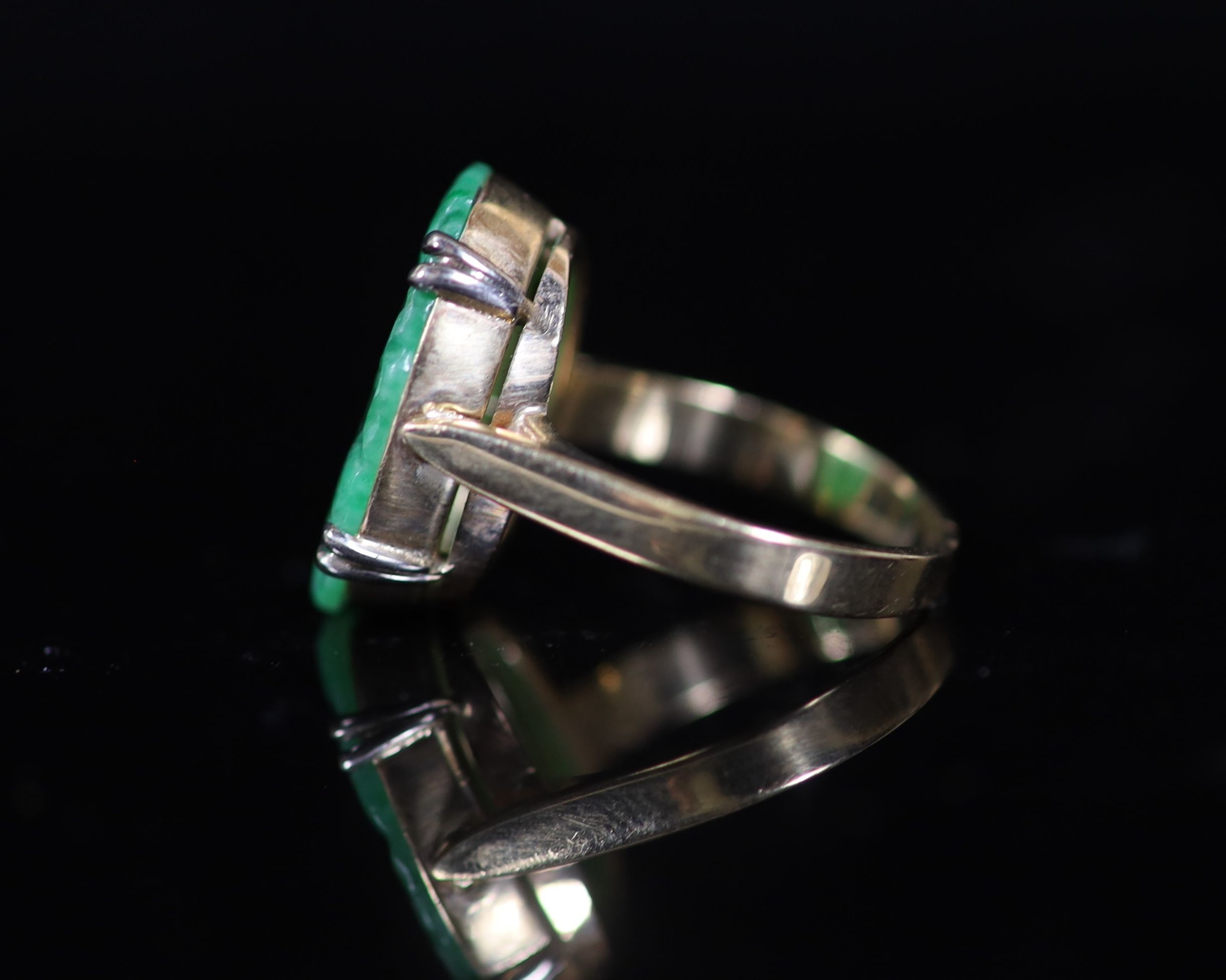 A mid 20th century gold and carved oval jade set dress ring